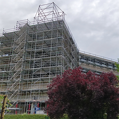 Photo du bâtiment CPAM de la Manche avec des échafaudages